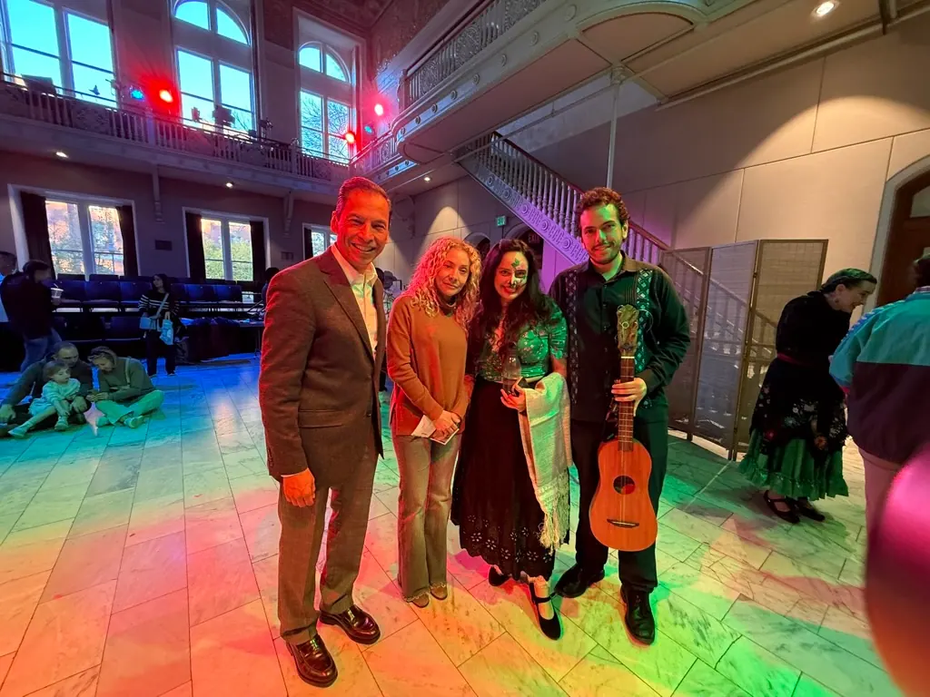 Artists and organizers under colored lights at the Día de Muertos Festival, Cambridge