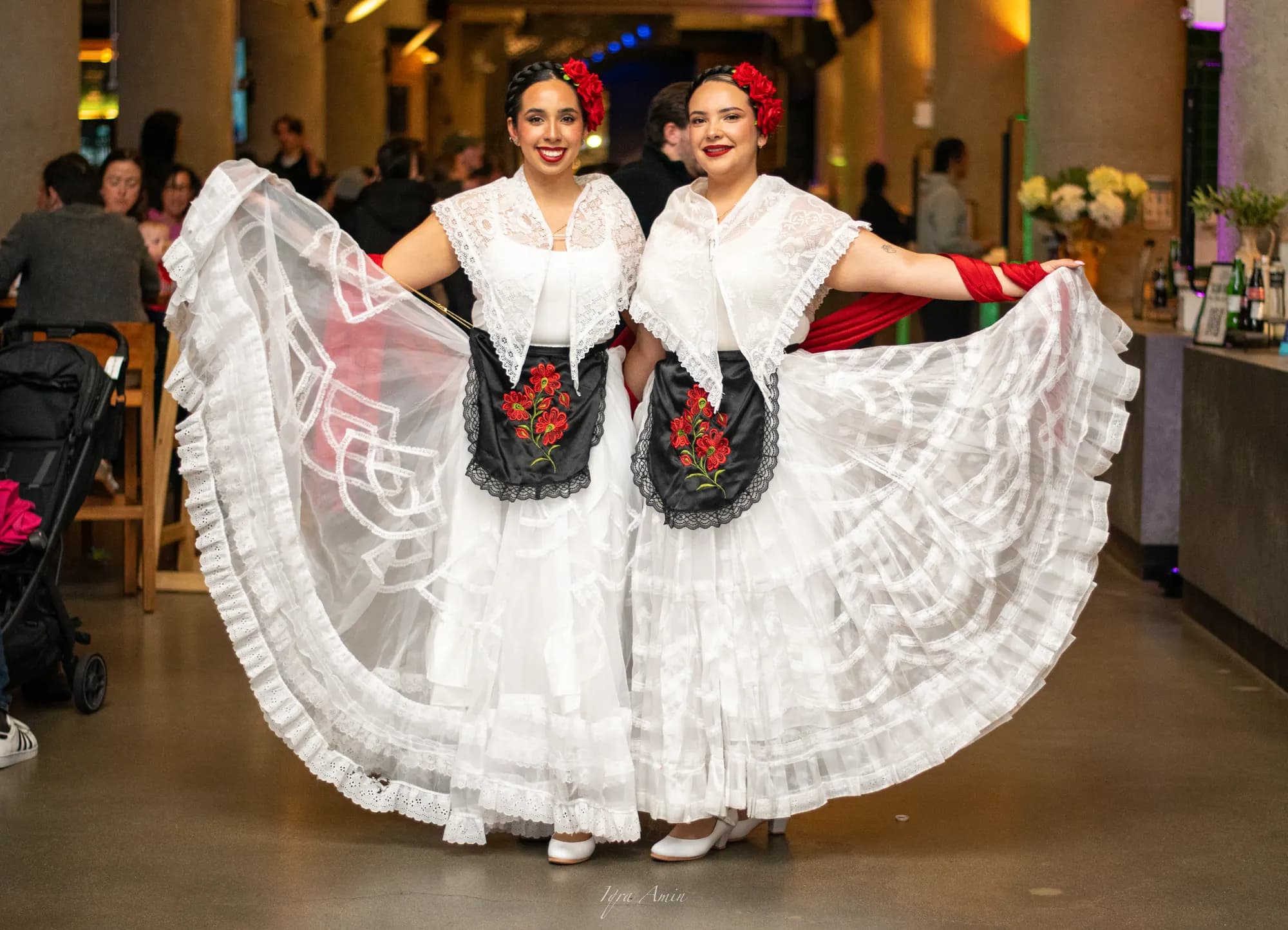 Two dancers in white at the market by night