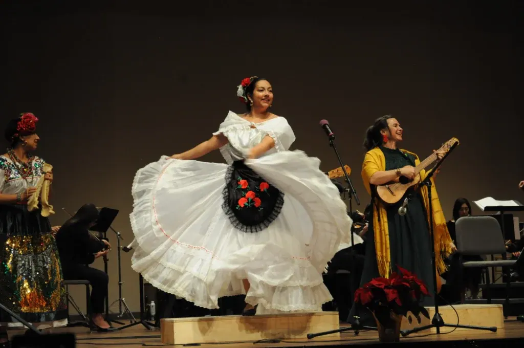 Bailadora de blanco con una jaranera en el escenario